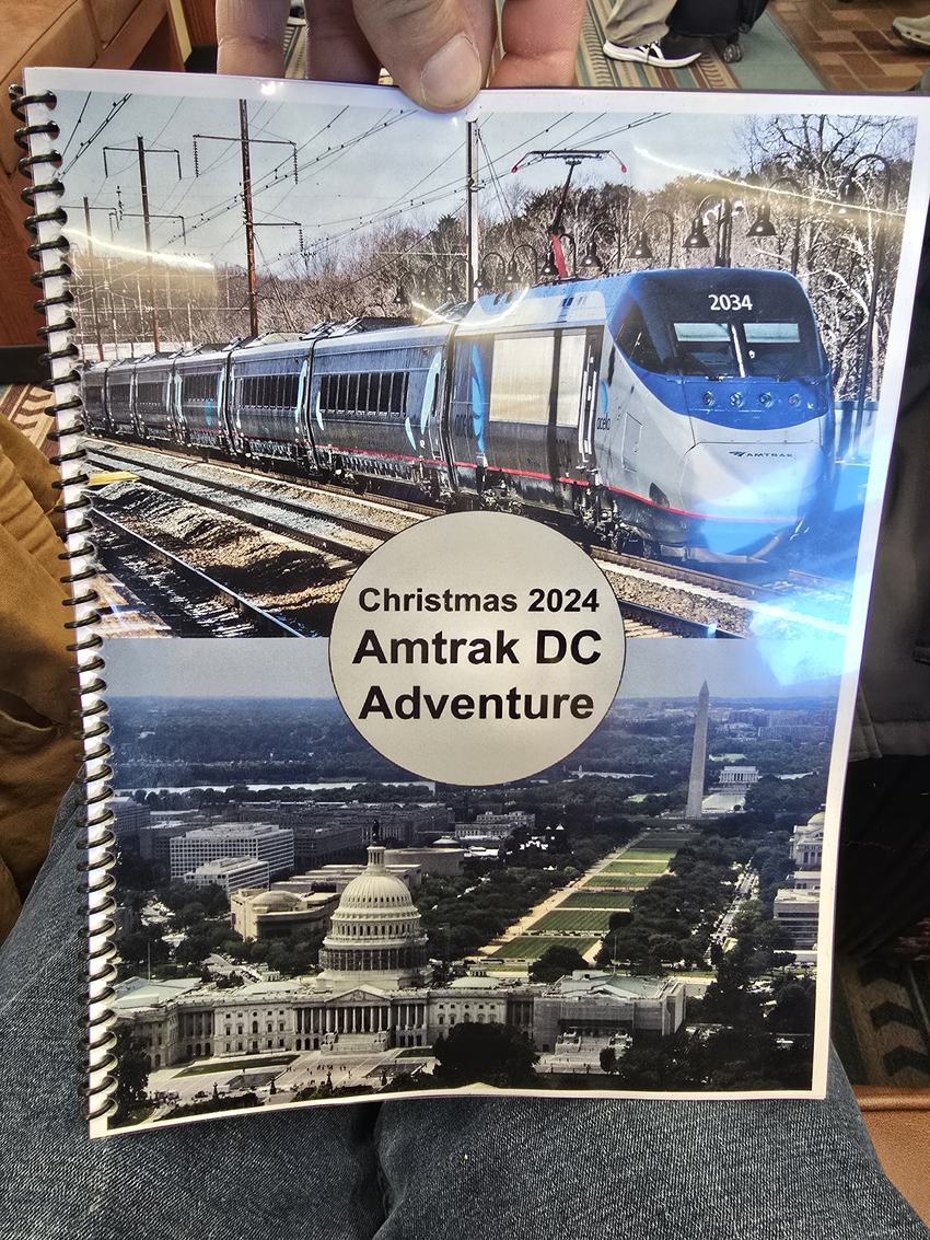 The spiral-bound Christmas 2024 Amtrak DC Adventure booklet